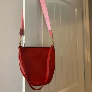 Clare V red bucket bag with pink crossbody strap
